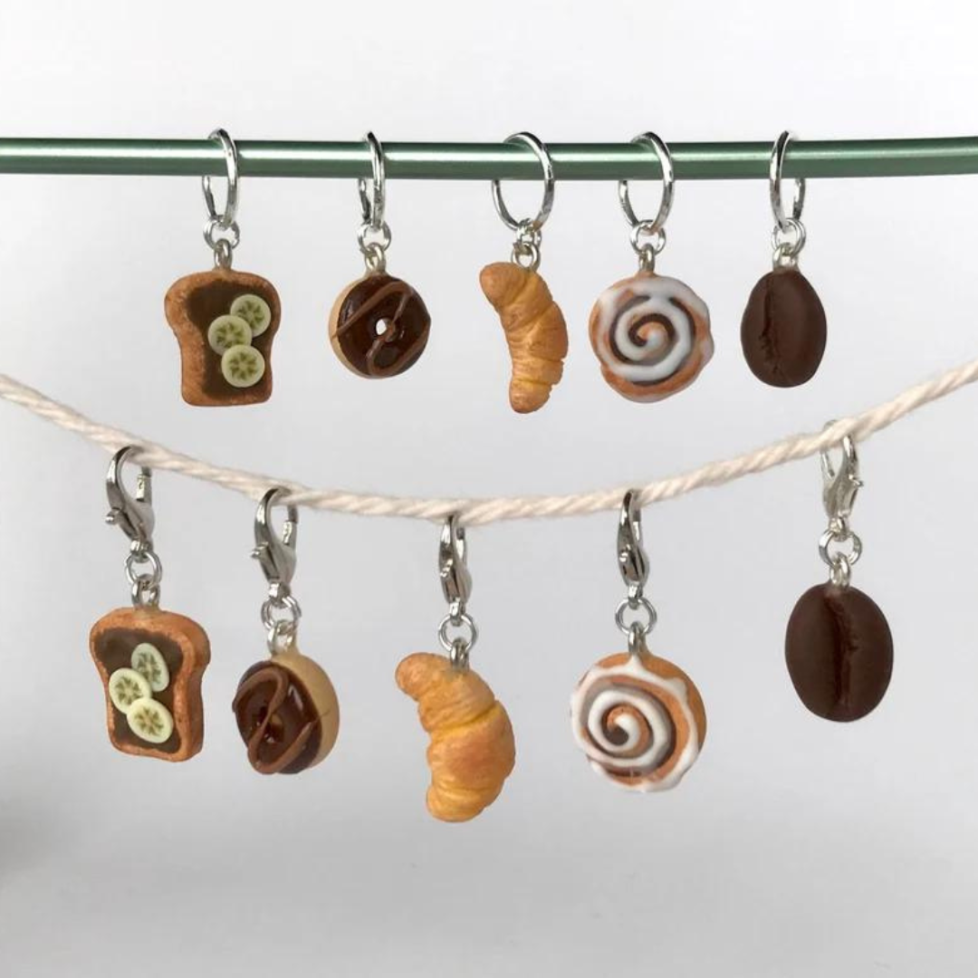 Five polymer clay breakfast inspired stitch markers hung on a string.