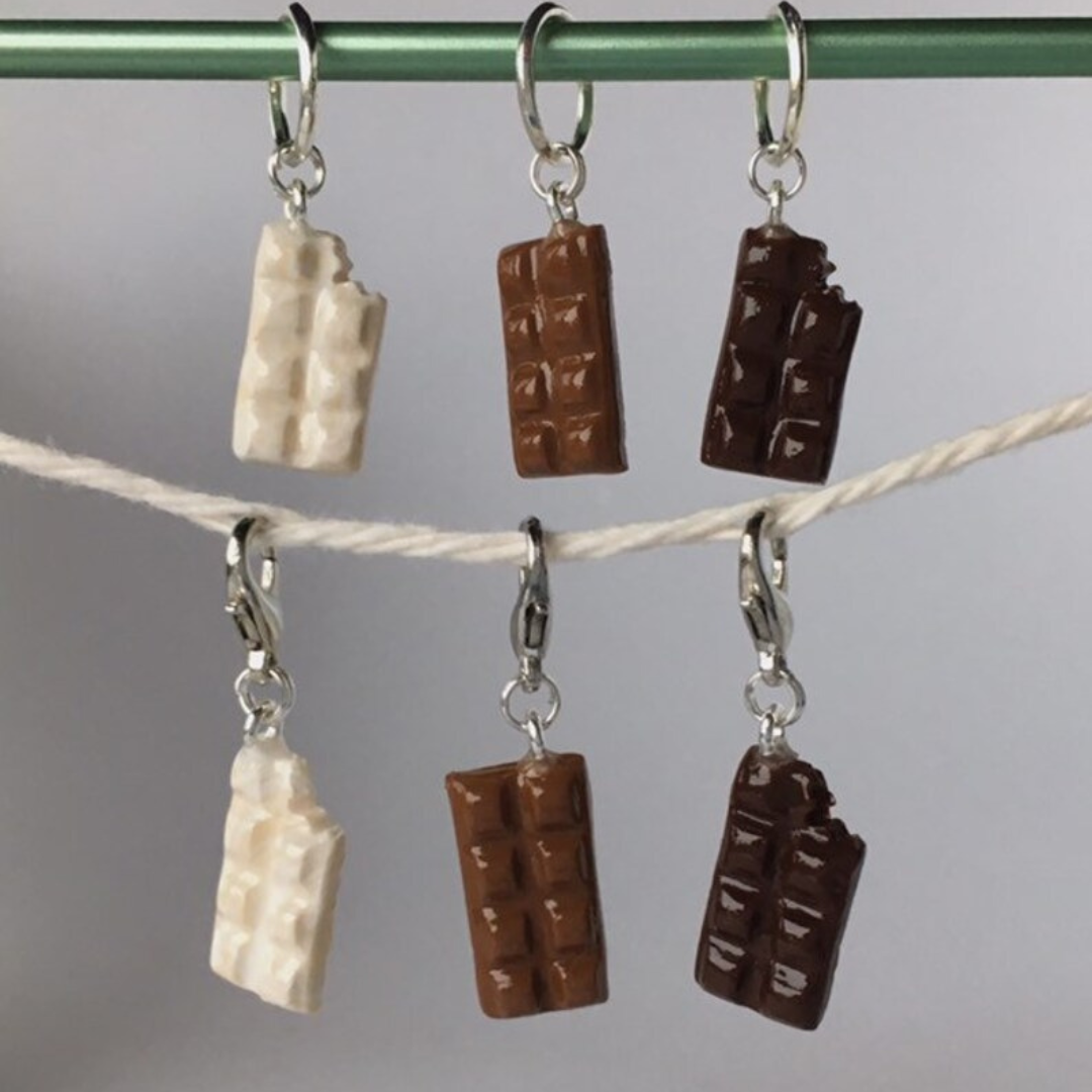 Three polymer clay chocolate bar stitch markers hanging on a string.