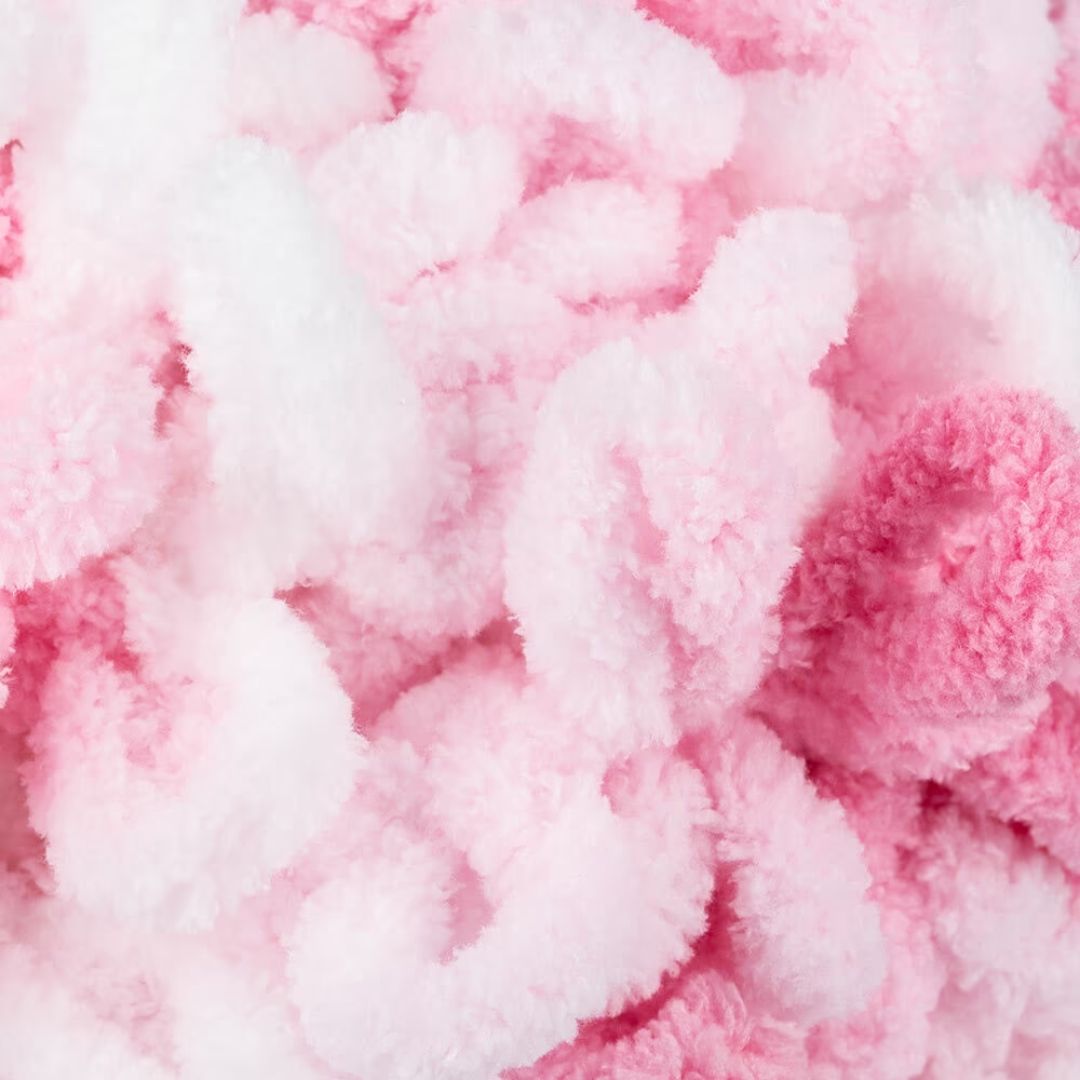 A close up of fluffy pink yarn with many loops.