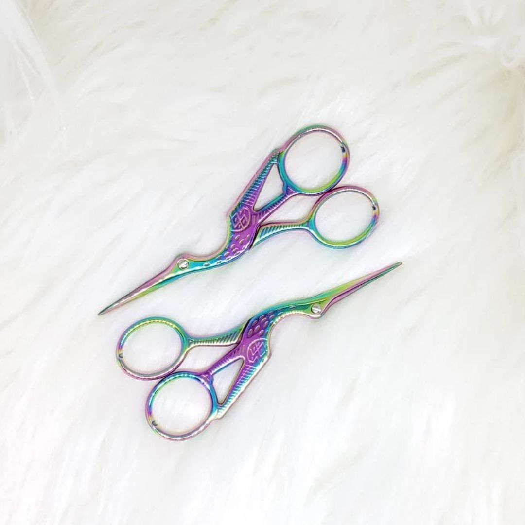 Rainbow iridescent yarn scissors engraved to look like a stork.