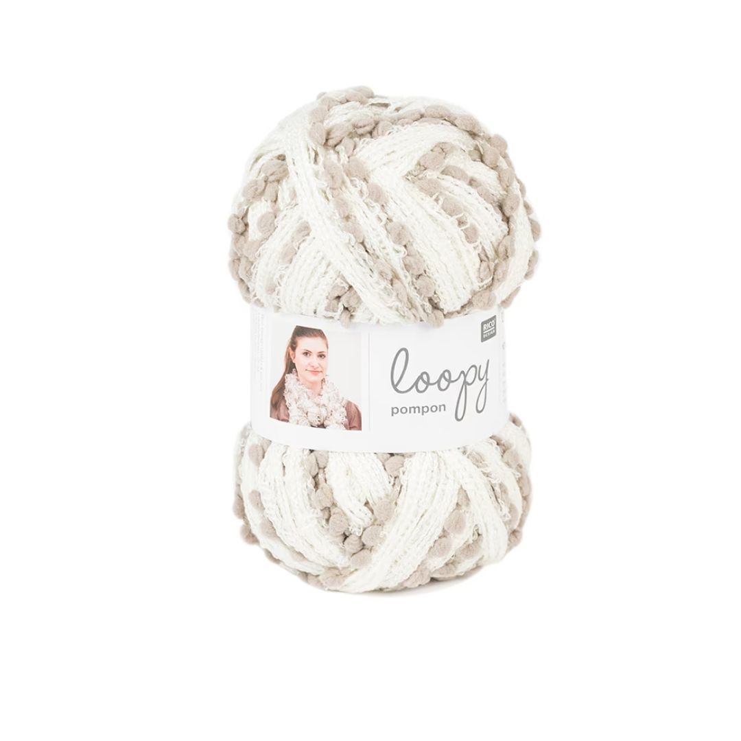 A skein of white and tan novelty yarn with pompoms.