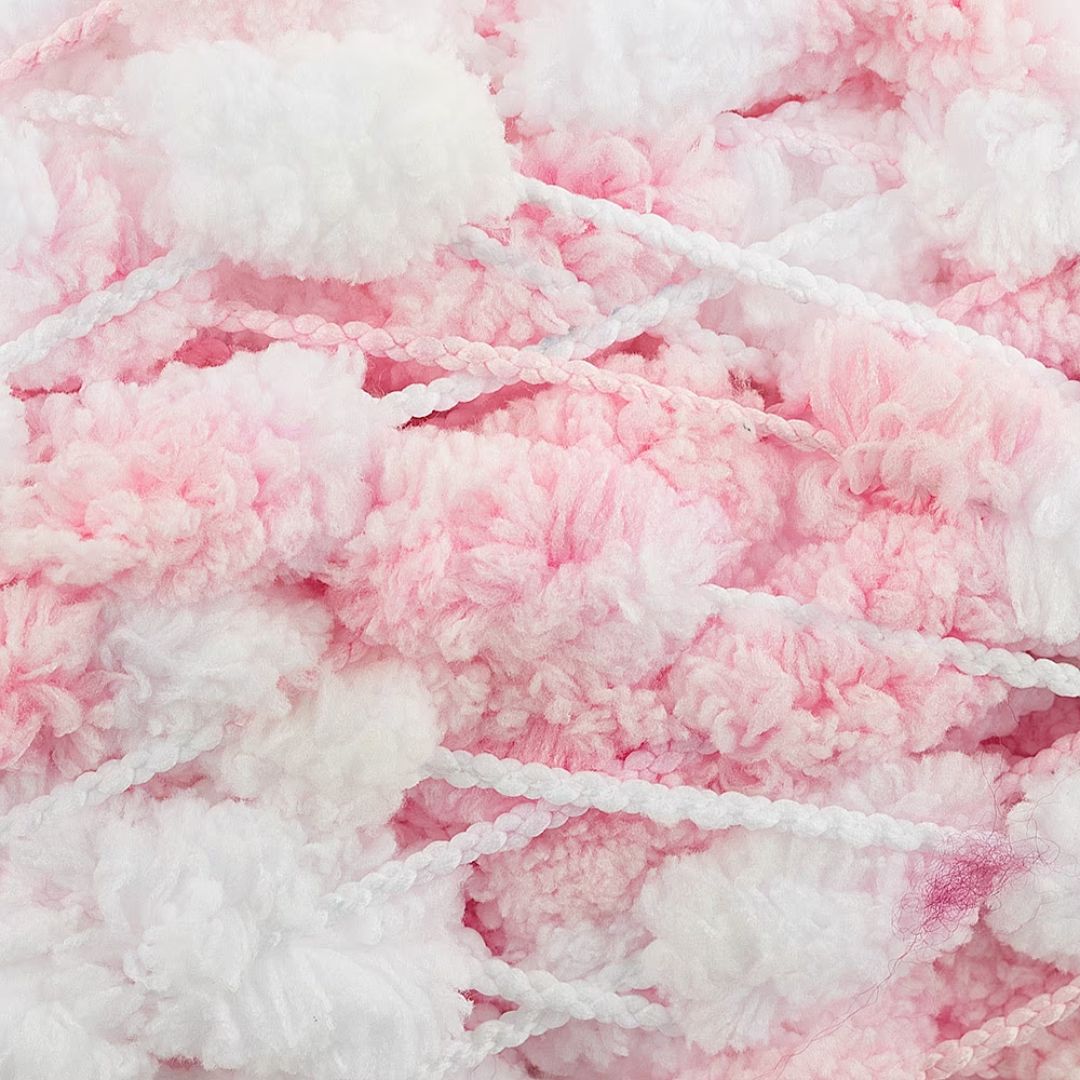 Close-up of white and pink pompom yarn.