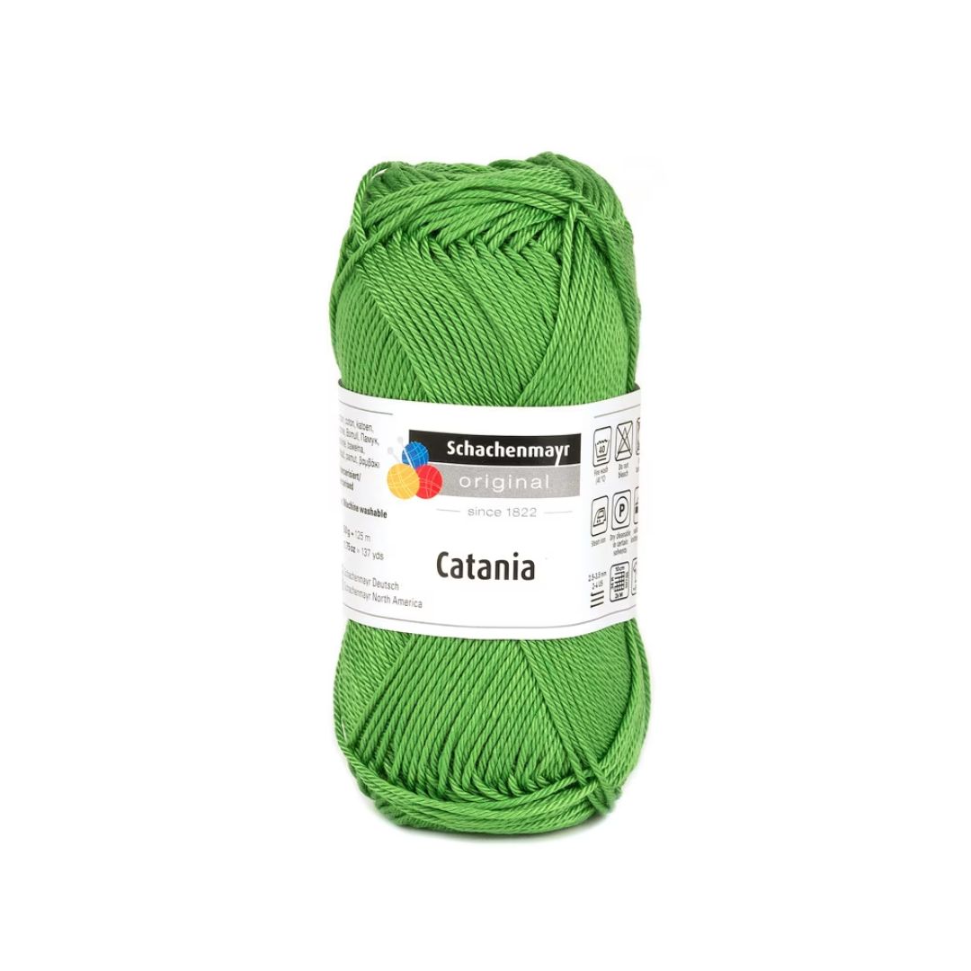 A ball of green Schachenmayr Catania cotton aran yarn.