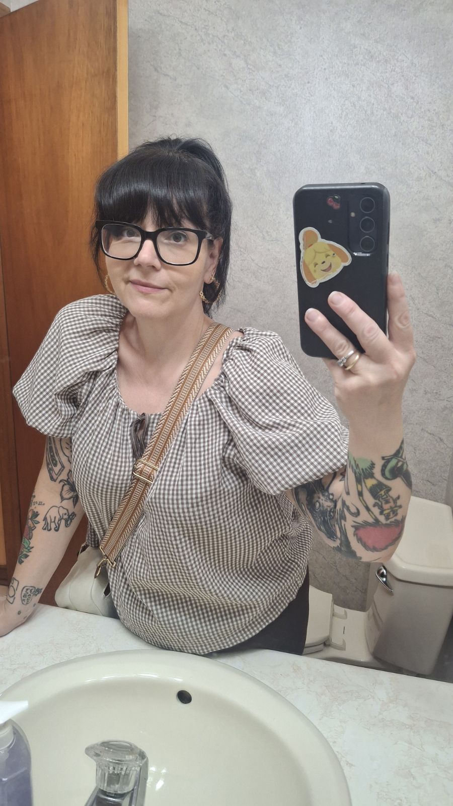 A mirror selfie in a gingham blouse