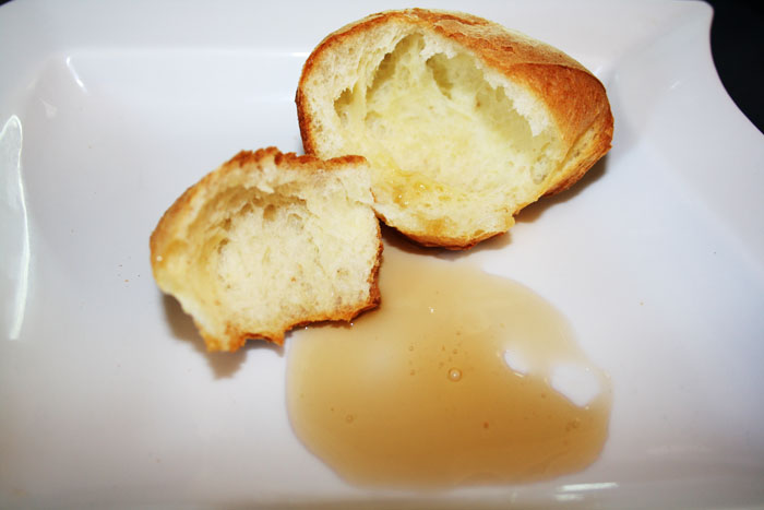Popovers with syrup on a white plate.